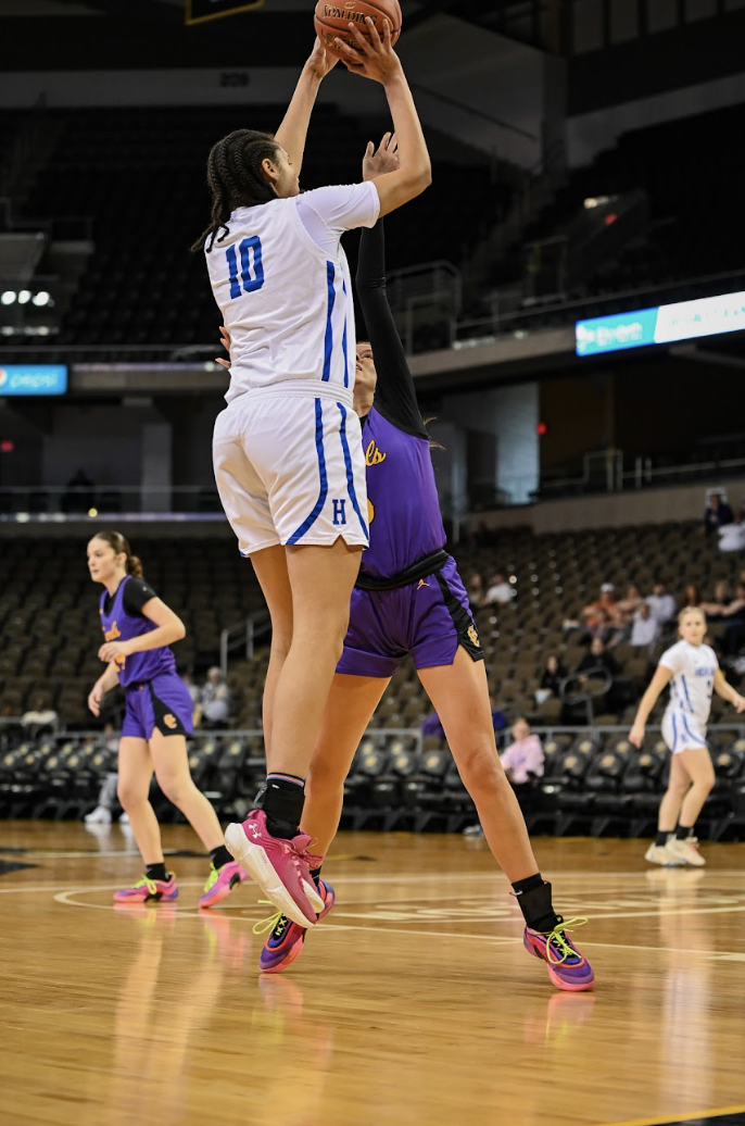 Marissa Green (12) shoots a three while being blocked. 